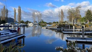 A marina with boats docked, calm water, and trees in the background. - Yasmin Cottage - for an instant holiday feel.  (Kinloch)