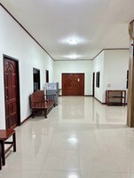 A hallway with a polished floor, wooden doors, and a bench.