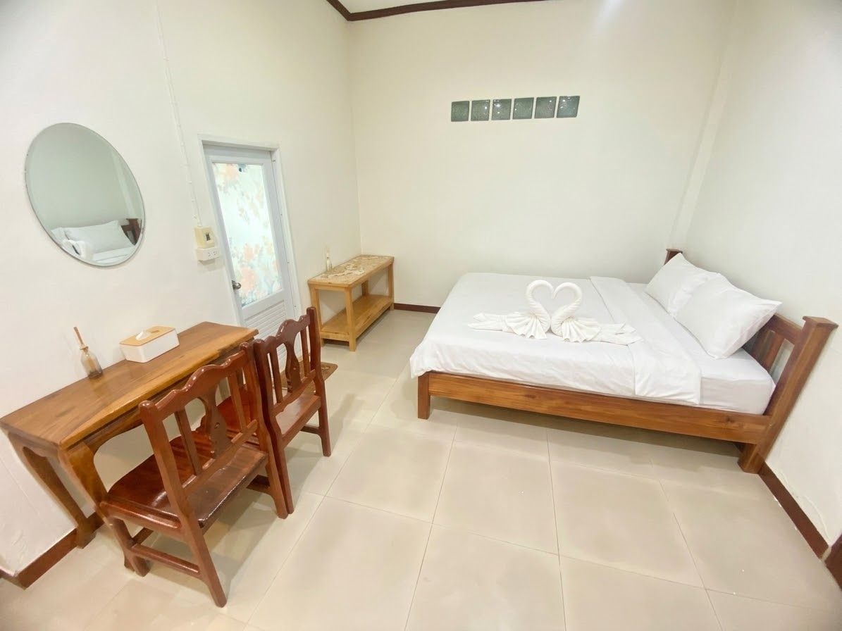 A bedroom with a bed, a desk, and a chair.