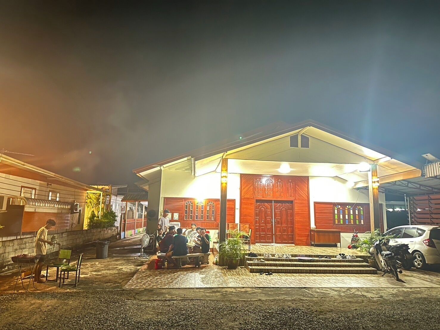 A building with a covered entrance and a group of people sitting outside.