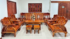 Comedor de madera tradicional con una mesa central, bancos y un jarrón decorativo.