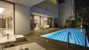 A modern indoor swimming pool with lounge chairs and a glass door entrance. - Vivienda Hotel Villas Jeddah (Jeddah)
