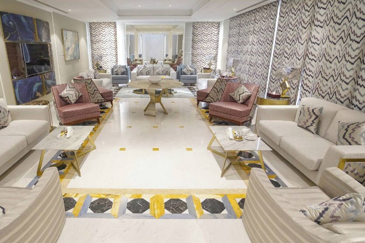 A spacious living room with a central coffee table, two sofas, and a patterned rug.