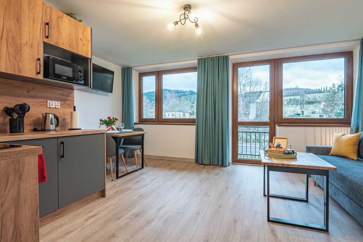 Eine moderne Küche mit Mikrowelle, Kaffeemaschine und einem Essbereich mit Tisch und Stühlen.