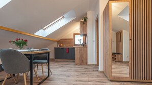 Un loft moderno con comedor, cocina y un amplio tragaluz.