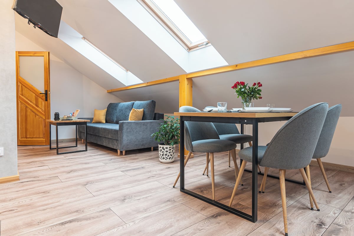 Eine moderne Loft-Wohnung mit Essbereich, einer Couch und einer Treppe.