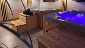 Un espacio de spa con dos jacuzzis y asientos de madera.