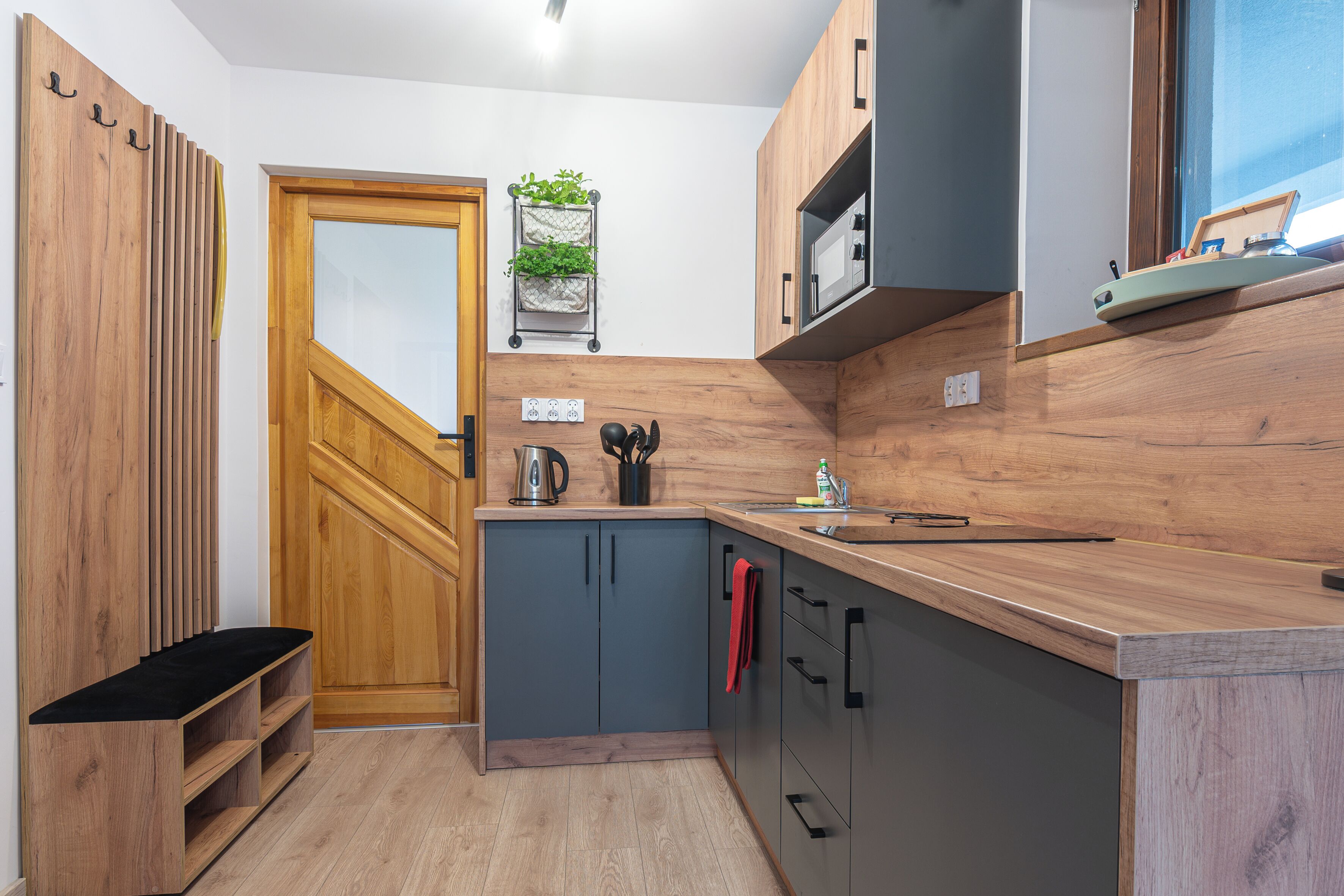 Una cocina compacta con armarios de madera, microondas integrado y una pequeña encimera.