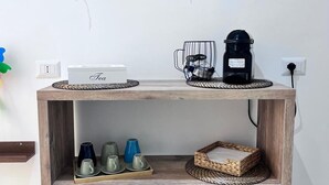 A wooden shelf unit with a coffee maker, tea set, and decorative balloons on the wall. - 1 Bedroom Private vacation home in Bari (Bari)