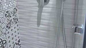 A bathroom with a shower, a towel rack, and a patterned shower curtain. - 1 Bedroom Private vacation home in Bari (Bari)