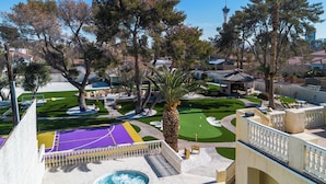 A pool area with a basketball court, palm trees, and a view of a tower in the background. - 15,000 sqft Mansion 5 min from strip! 1.5 acre compound.  (Las Vegas)