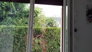 Une pièce dotée d’une grande fenêtre, de murs blancs et d’une porte avec un interrupteur.