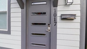 A gray door with the number 1017, a mail slot, and a small window above the door. - Historic Fountain Sq in DT Indy (Indianapolis)
