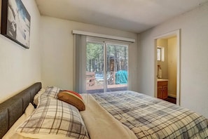Une chambre avec deux lits, une grande fenêtre et une vue sur l’extérieur.
