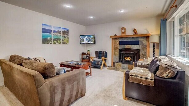 Una sala de estar con chimenea, televisor y sofá.