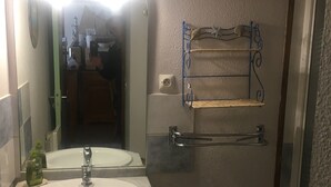 A bathroom with a sink, mirror, and towel rack.