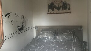 A bedroom with a bed, a wall clock, and a poster.