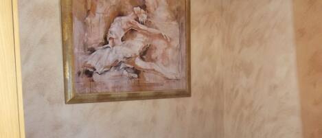 A bedroom with two single beds, a wooden wardrobe, and a painting on the wall.