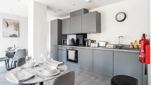 Una cocina moderna con armarios grises, un microondas y un extintor.