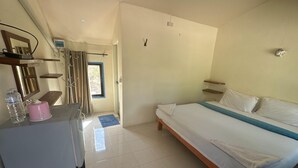 Une chambre à coucher avec un lit, un bureau, une chaise, un miroir, une fenêtre et une porte.
