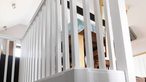 A white staircase with vertical balusters, a wooden door, and a brown carpeted area.