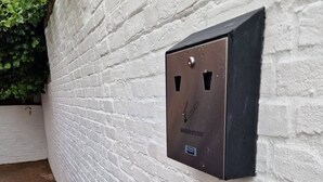 A metal box labeled "SMOKERS STATION" mounted on a white brick wall. - Stay Norwich Apartments Riverside House Apart-1 (Norwich)