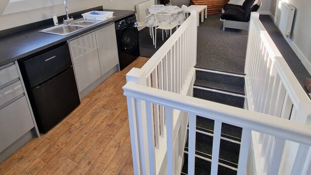 A modern loft apartment with a kitchen, dining area, and living room.