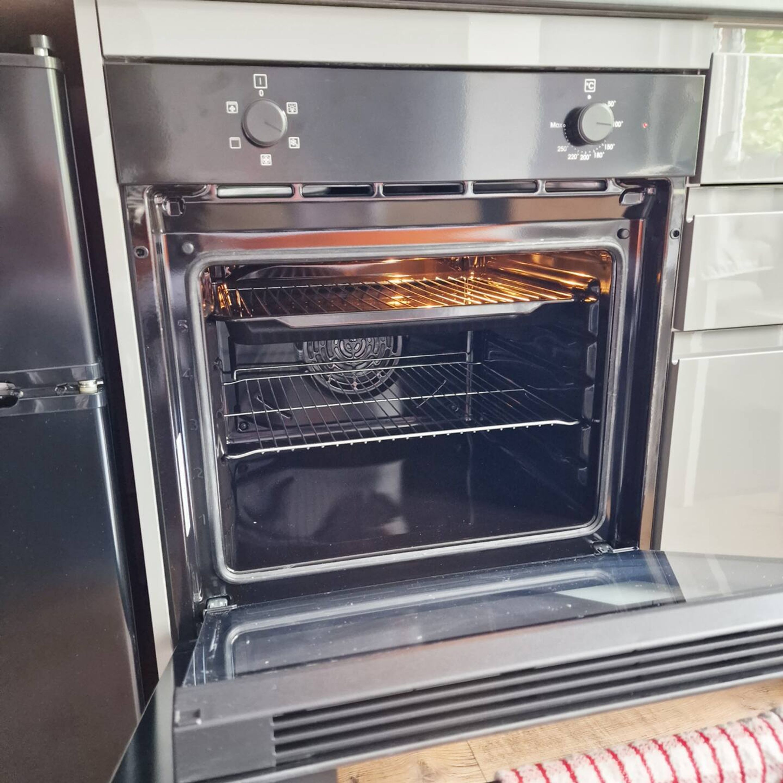 An open oven with a control panel above it.