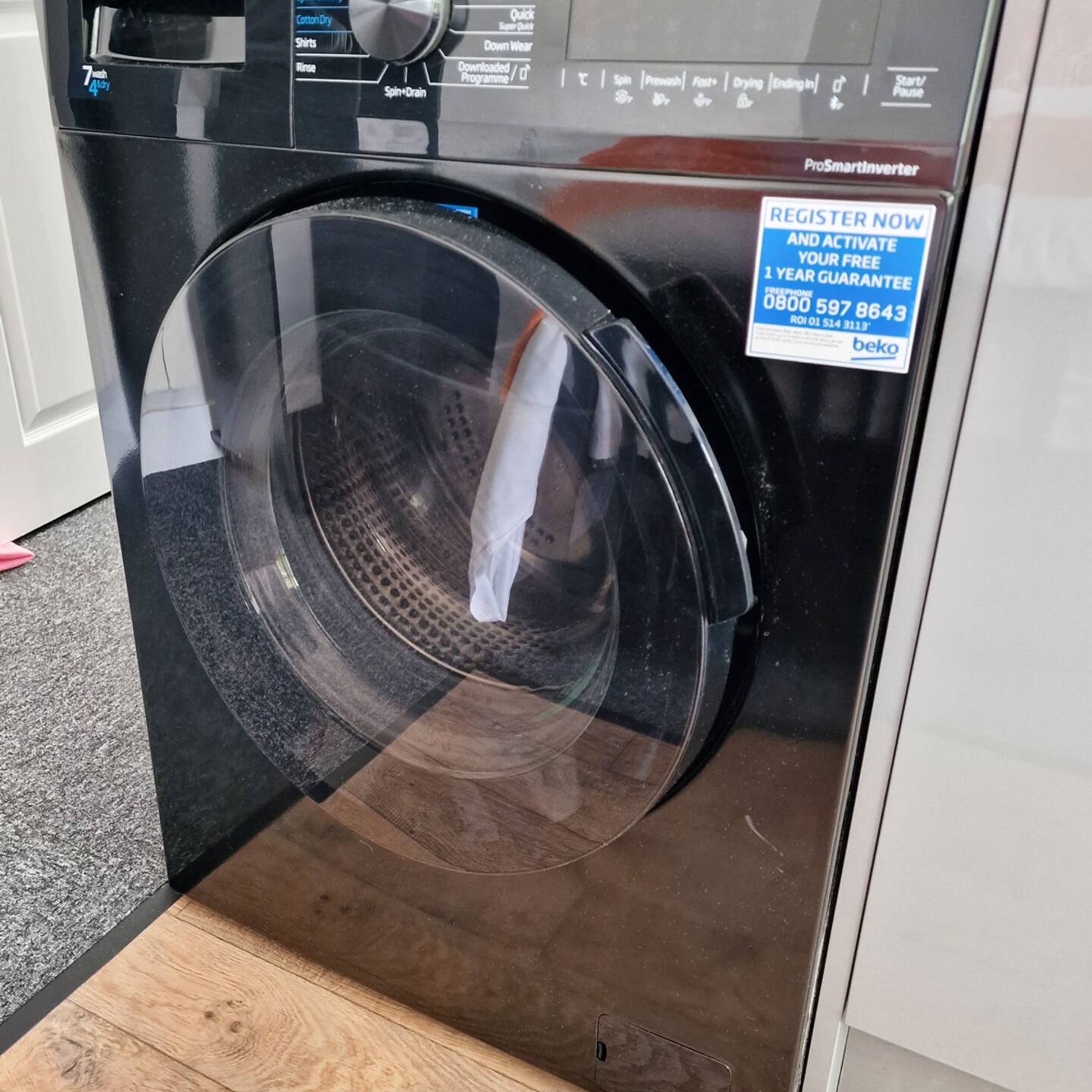 A ProSmartinverter washing machine with a transparent door, a control panel with various settings, and a registration sticker.