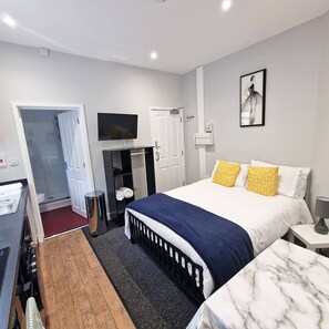 A hotel room with a bed, a desk, a TV, a wardrobe, and a bathroom. - Stay Norwich Apartments Riverside House Apart-3 (Norwich)