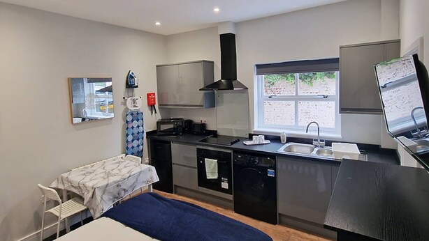 A compact hotel room with a bed, a small kitchenette, a window, and a desk. - Stay Norwich Apartments Riverside House Apart-3 (Norwich)