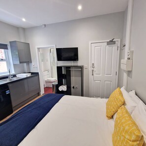 A hotel room with a bed, a TV, a wardrobe, a mirror, and a bathroom. - Stay Norwich Apartments Riverside House Apart-3 (Norwich)