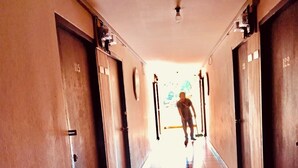 Un largo pasillo con puertas a ambos lados, que conduce a habitaciones.
