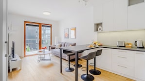 Une cuisine moderne avec un coin repas, un canapé et un téléviseur.