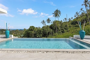 Ein rechteckiger Swimmingpool mit klarem, blauem Wasser, umgeben von einem Kiesstreifen.