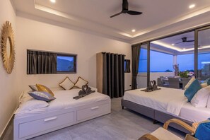 A modern hotel room with two beds, a large window, and a balcony.