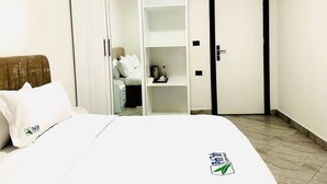 A hotel room with a bed, a wardrobe, and a door. - Yohannes Guesthouse Addis (Addis Ababa)