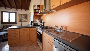 Una cucina con mobili in legno, un lavello in acciaio inossidabile e un fornello.