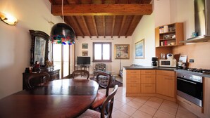 Una cucina con mobili in legno, un tavolo da pranzo e un'ampia finestra.