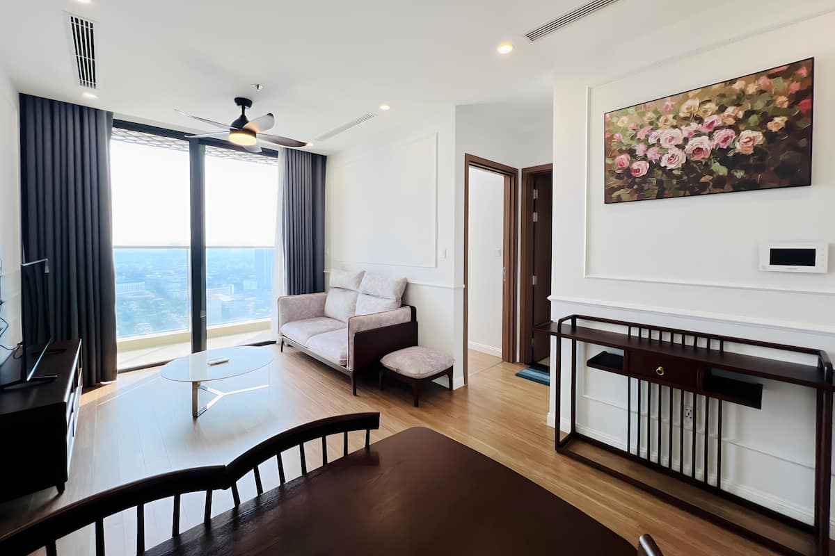 Un salon moderne avec un canapé, une table à manger et une vue sur la ville.