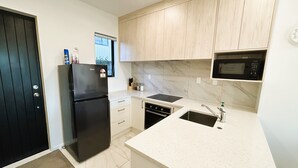 Een moderne keuken met een zwarte koelkast, een magnetron en een vaatwasser.