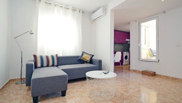 A modern living room with a grey sofa, a small round coffee table, and a floor lamp. - Ático en Cambrils (Cambrils)