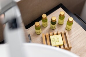 A wooden tray with six olive oil bottles and a bar of soap. - The Point Suites Rome – Guest House (Rome)