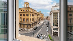 Une vue de rue avec des bâtiments historiques, un ciel dégagé et un bâtiment moderne sur la droite.