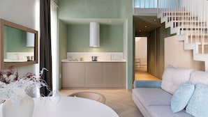 A modern interior with a kitchen island, a sofa, and a staircase. - Palazzo Ciopeta (Verona)