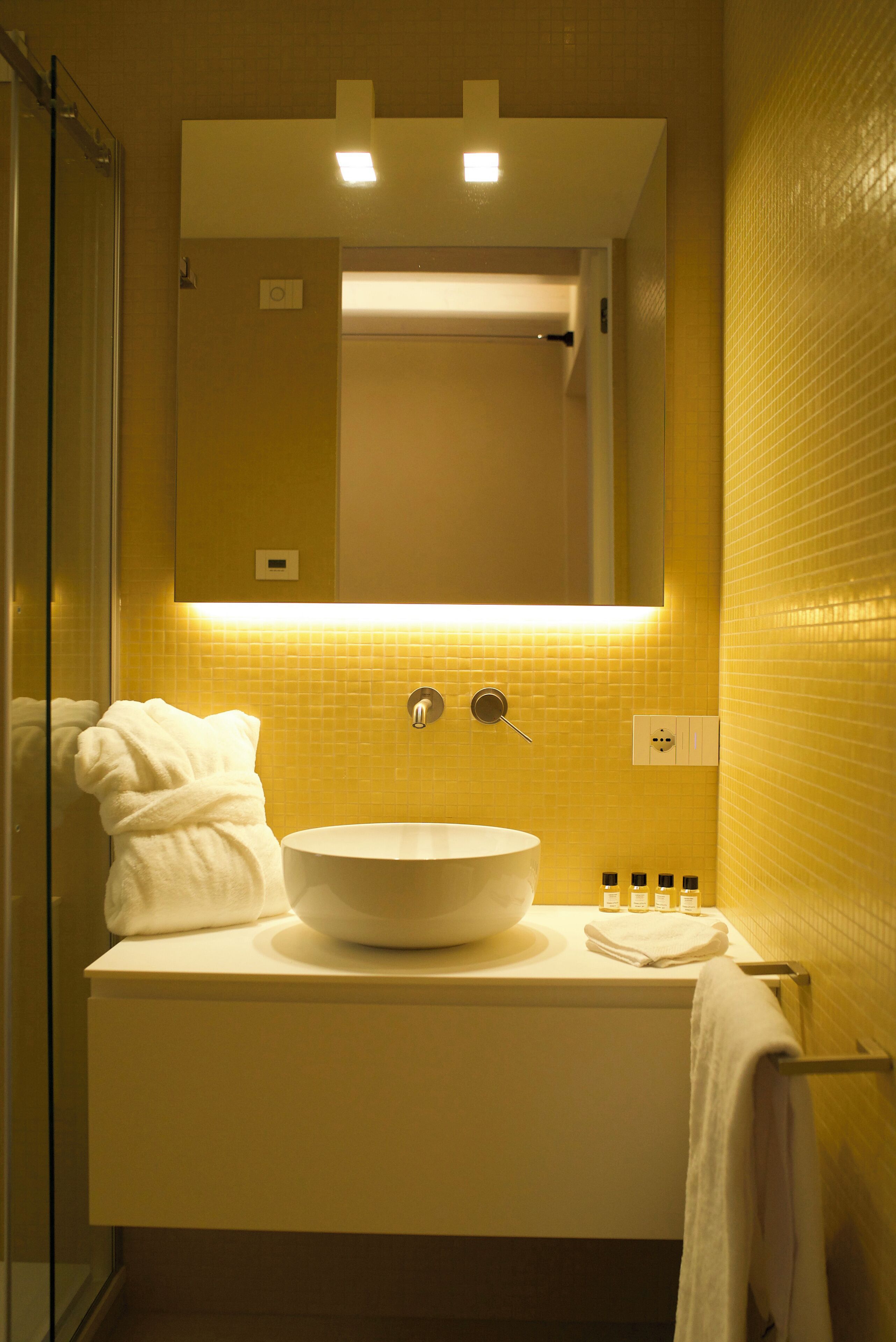A bathroom with a white sink, a mirror above it, and a glass shower enclosure.