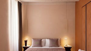 A modern bedroom with a large bed, two bedside tables, and a bench. - Palazzo Ciopeta (Verona)