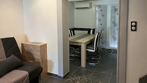 Una habitación moderna con una mesa de comedor, sillas y un armario.