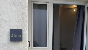 Una entrada de edificio con una puerta que da a una escalera. Se ve un cartel con el número 
