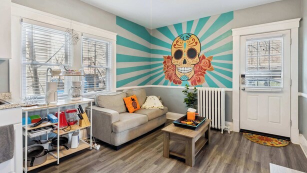 Un salon avec un canapé, une table basse et une fresque murale.